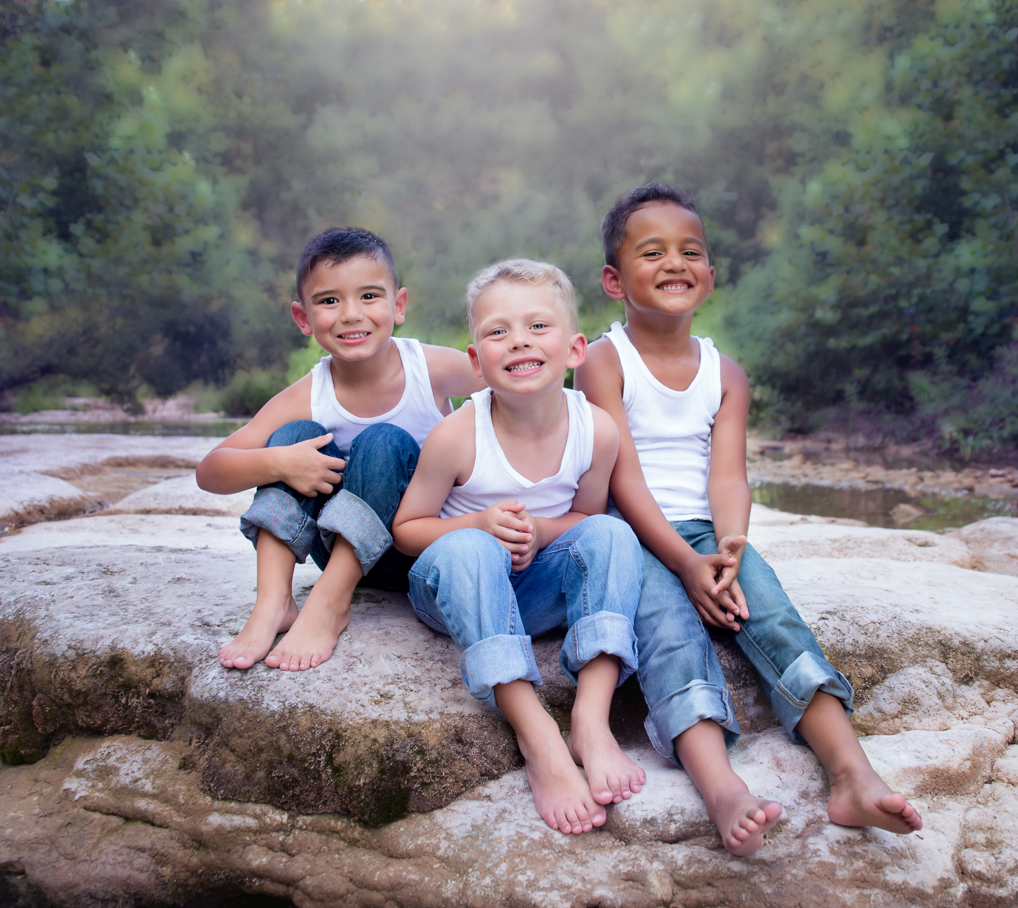3 toddlers sitting on a rock