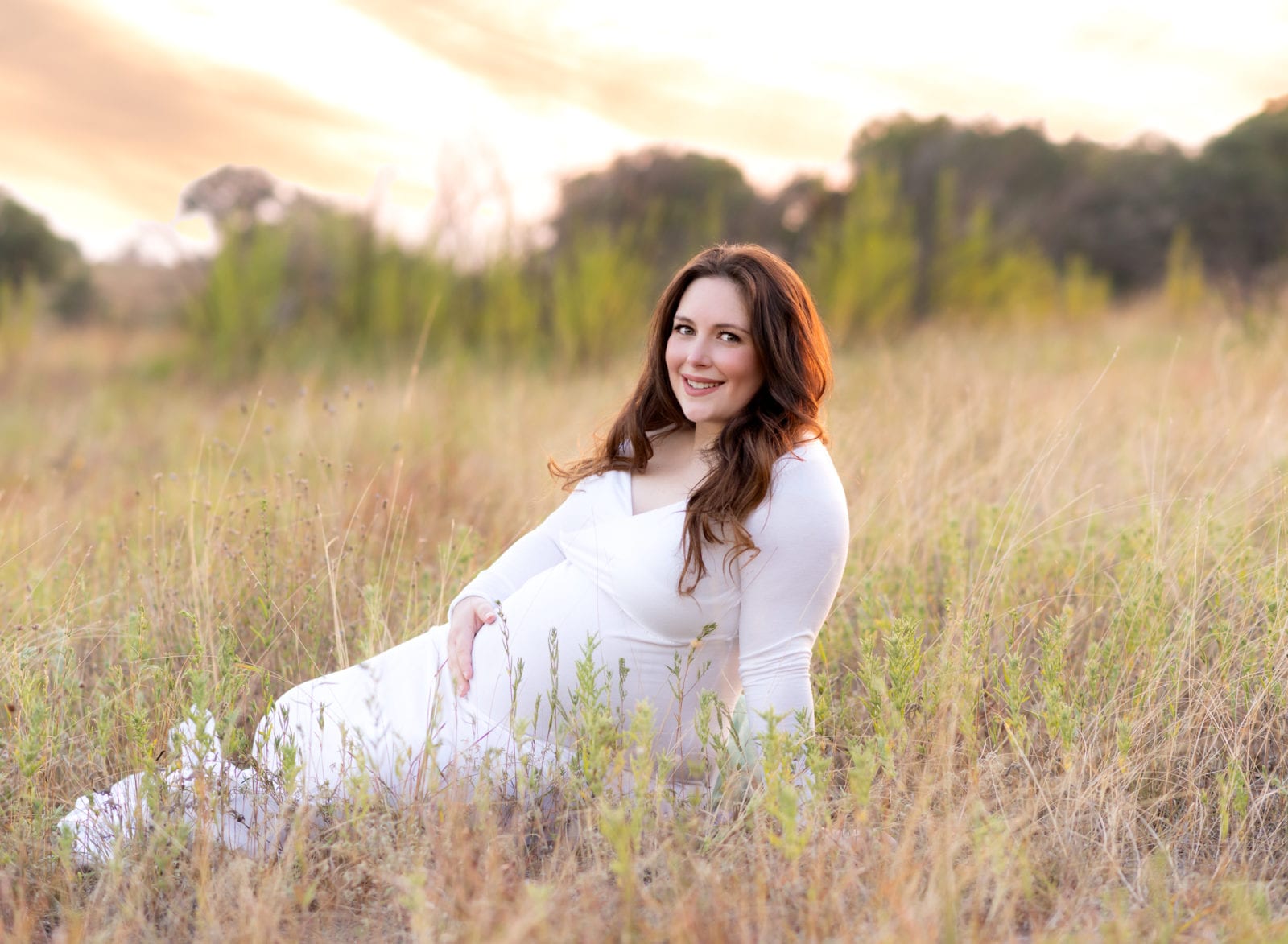 Maternity pics in a field at sunset.