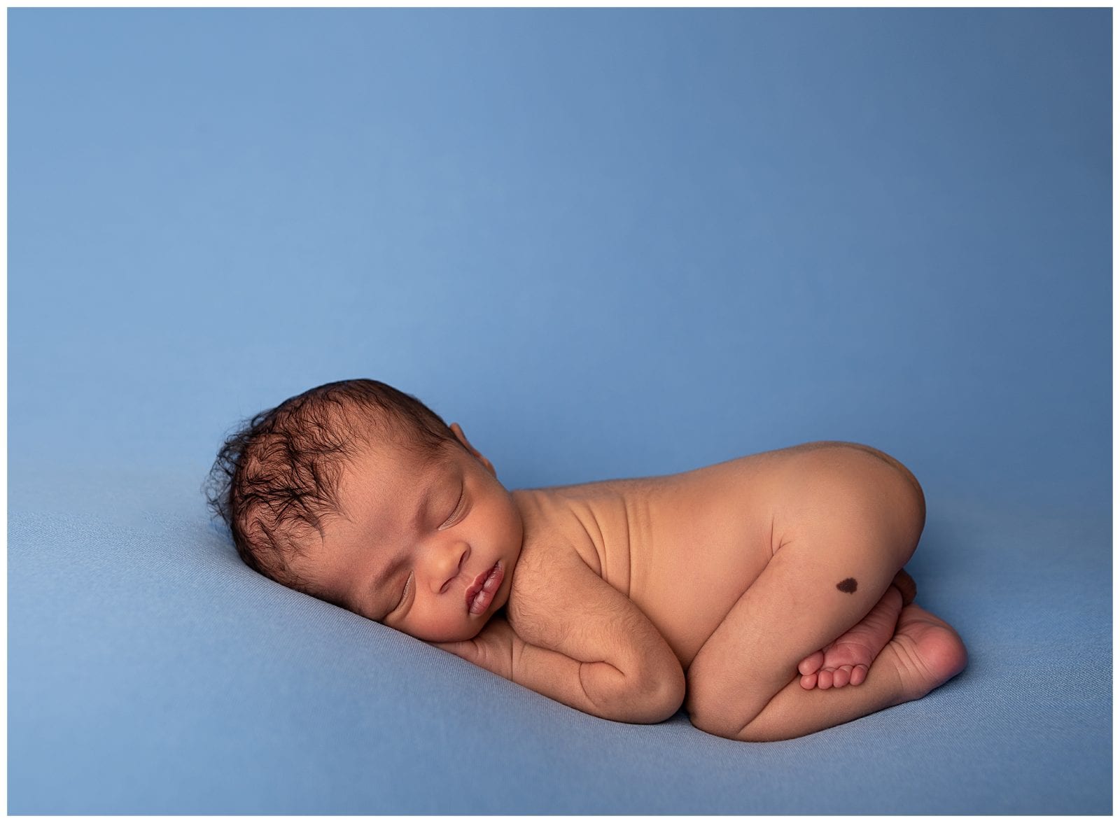 newborn sleepy pose on blue