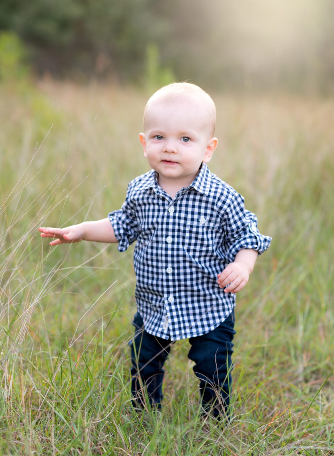 1 year old boy walking in the grass
