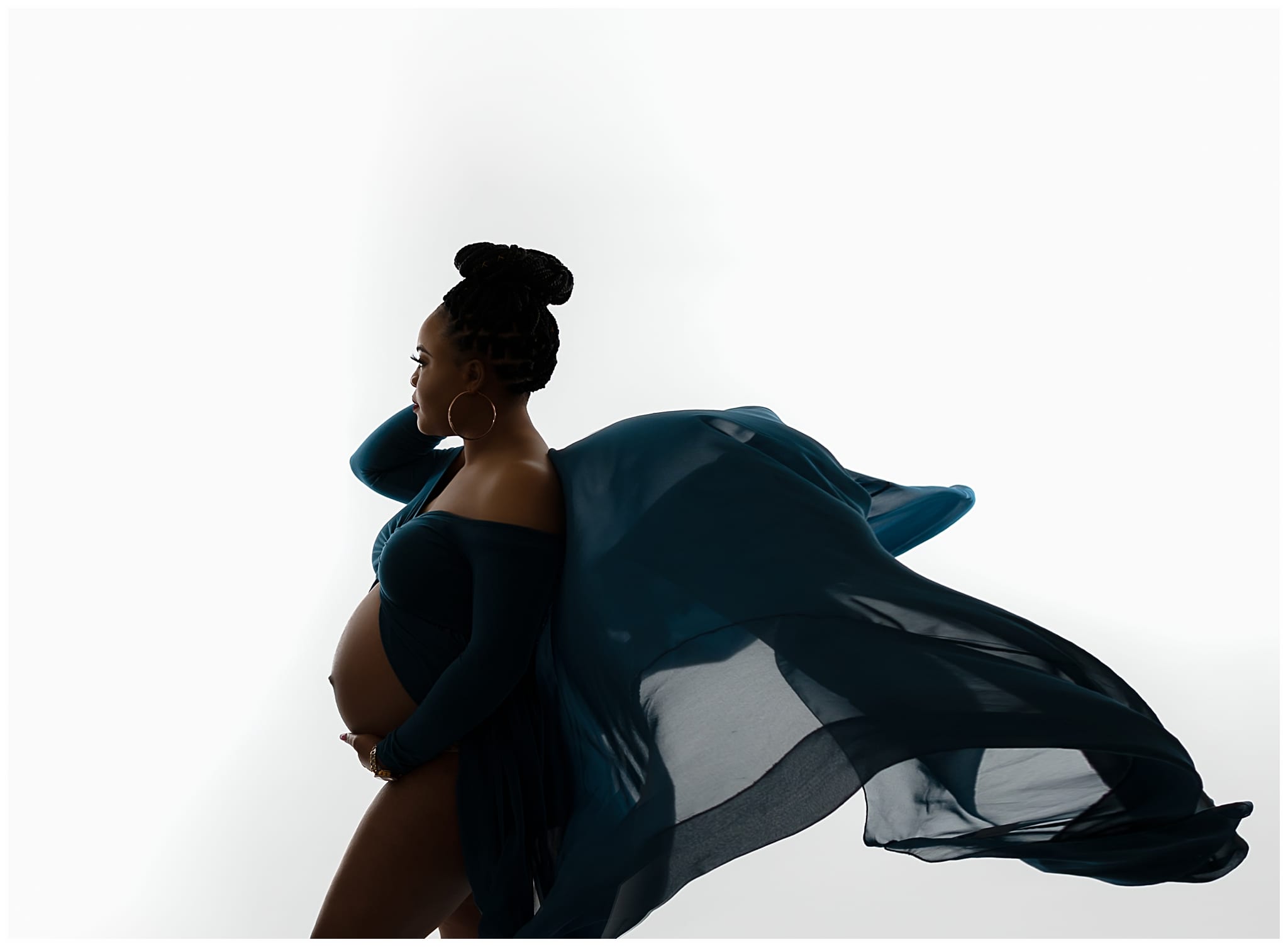 african american pregnant woman wearing a teal dress that is flying through the air behind her
