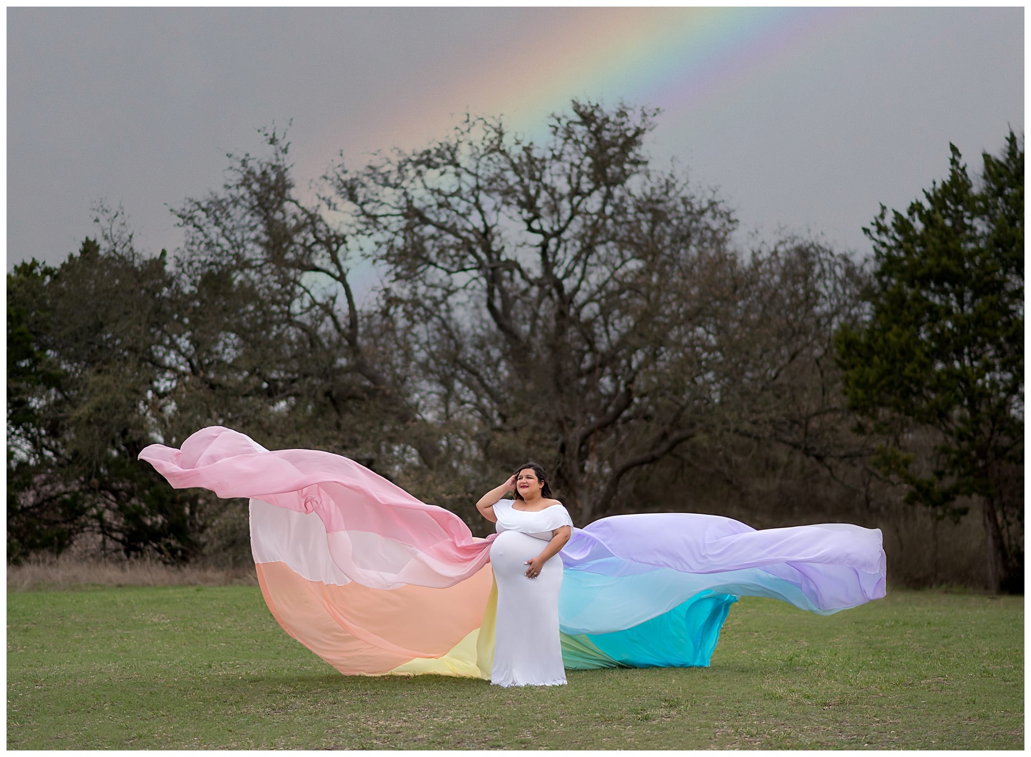 Maternity photo in flying rainbow dress.