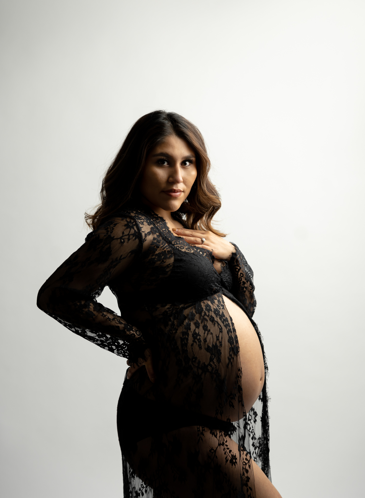maternity photo of a woman in a black lace dress