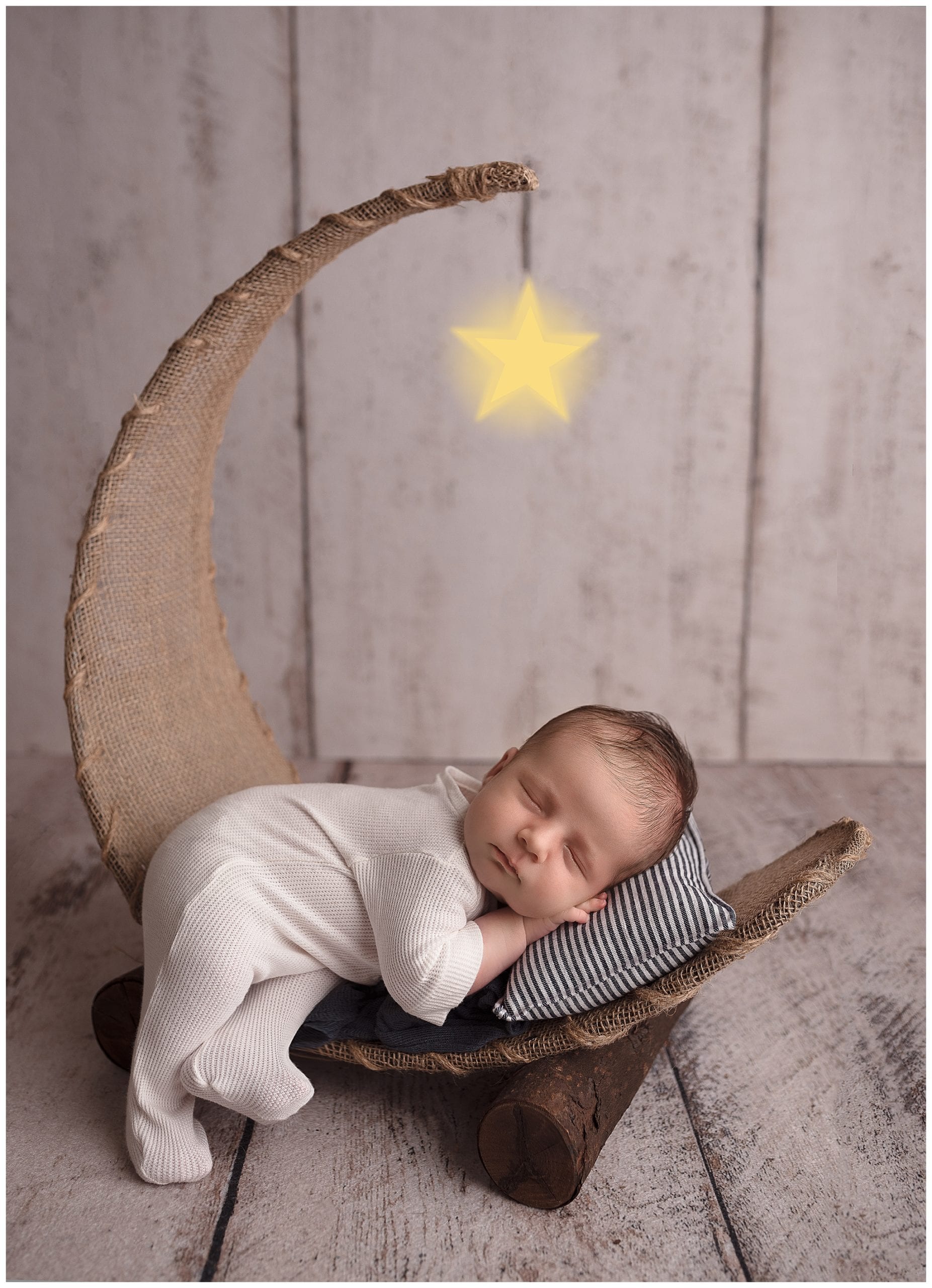 newborn baby sleeping in a moon prop
