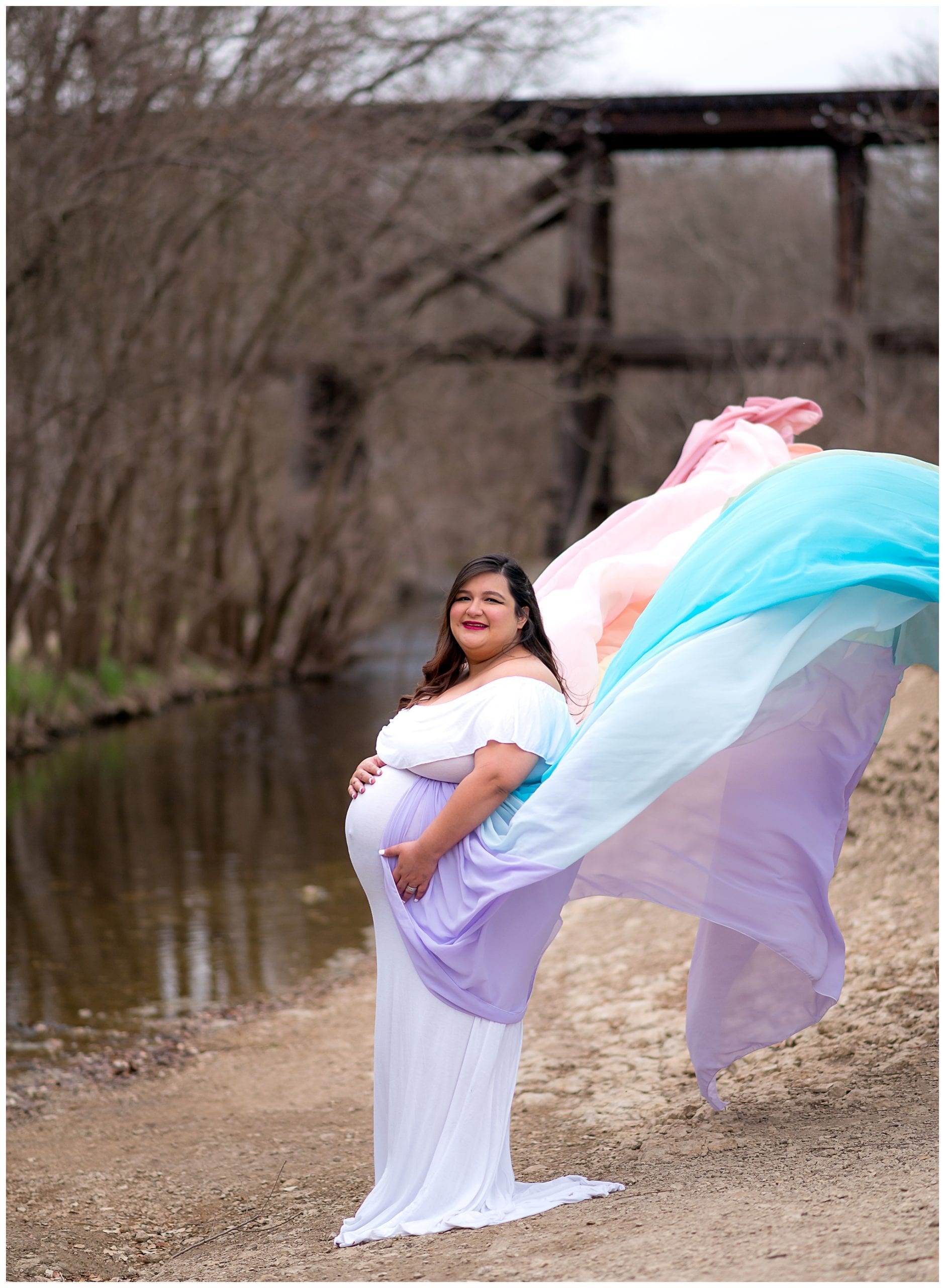 Maternity photo in flying rainbow dress.