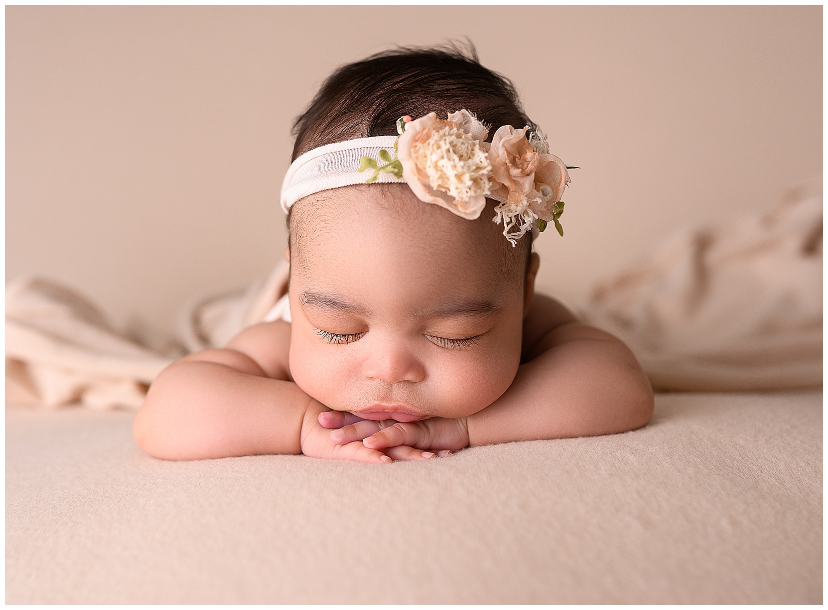 sleeping baby on pink with her head on her hands