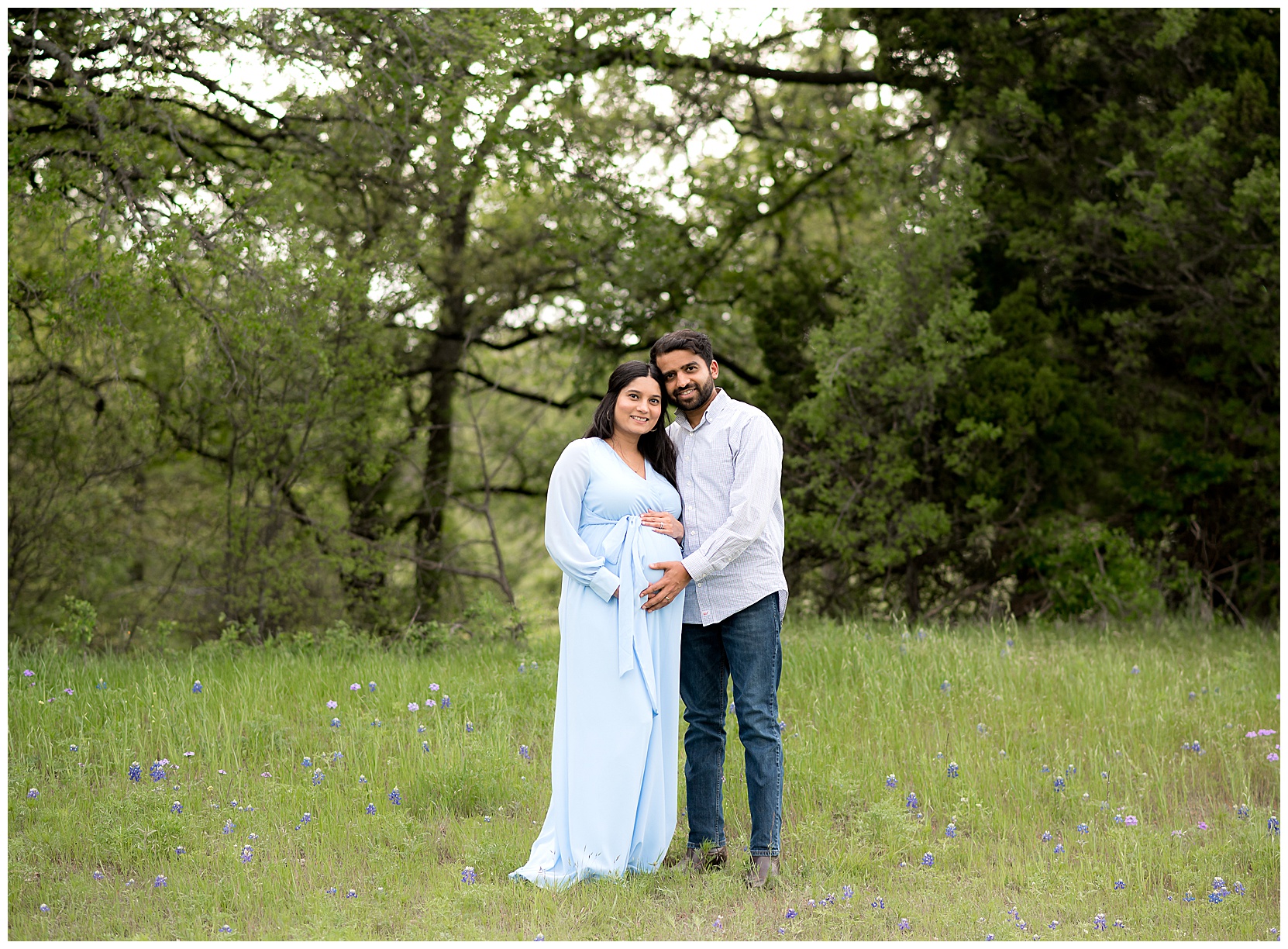 pregnant woman wearing blue with husband in bluebonnets
