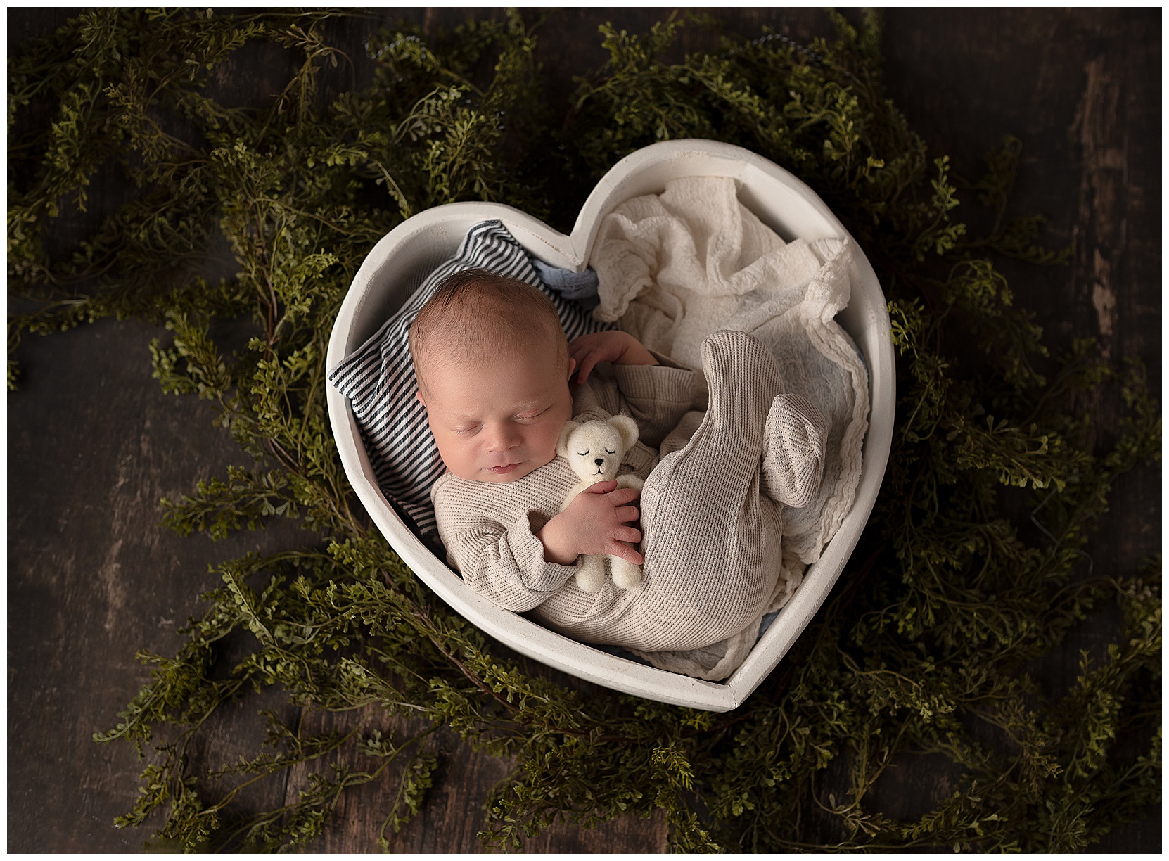 baby sleeping in a white heart bowl
