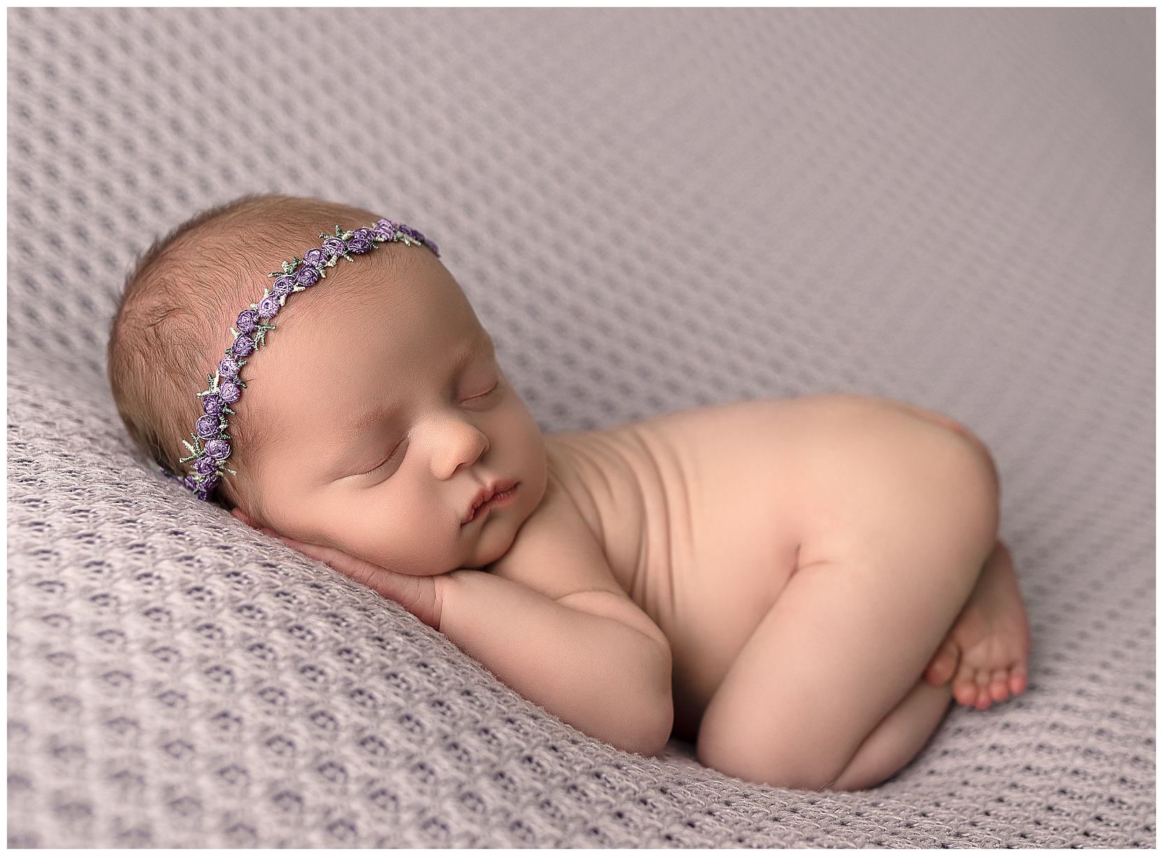 sleeping naked baby on a purple blanket with her bum up
