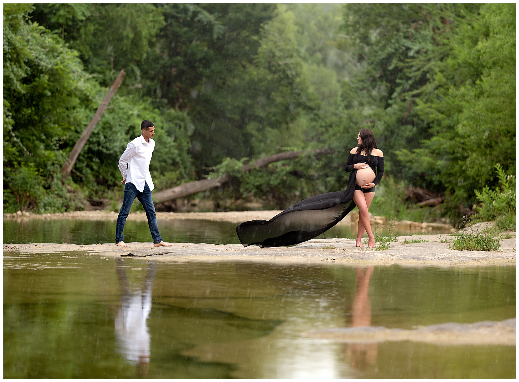 maternity photo at an austin creek with a black flowy dress