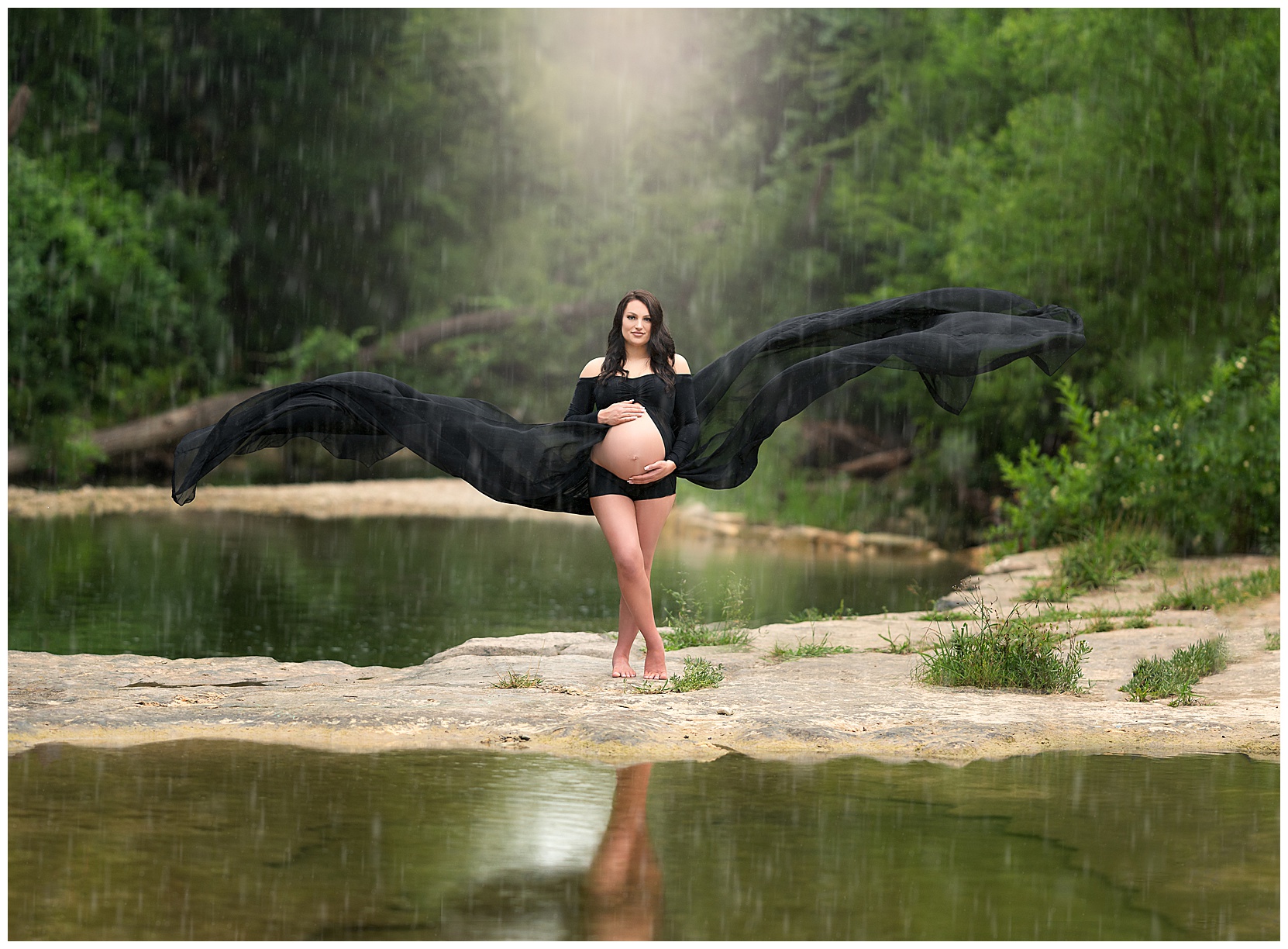 rainy maternity photos at an austin creek with a black flowy dress
