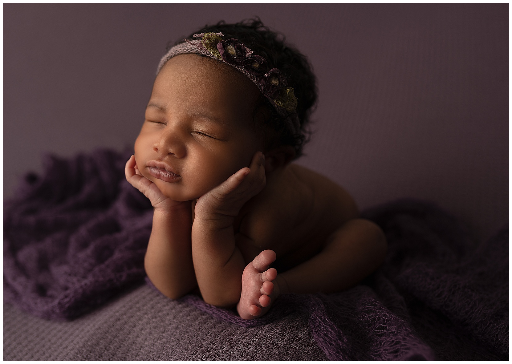 baby in the froggy pose on purple fabric