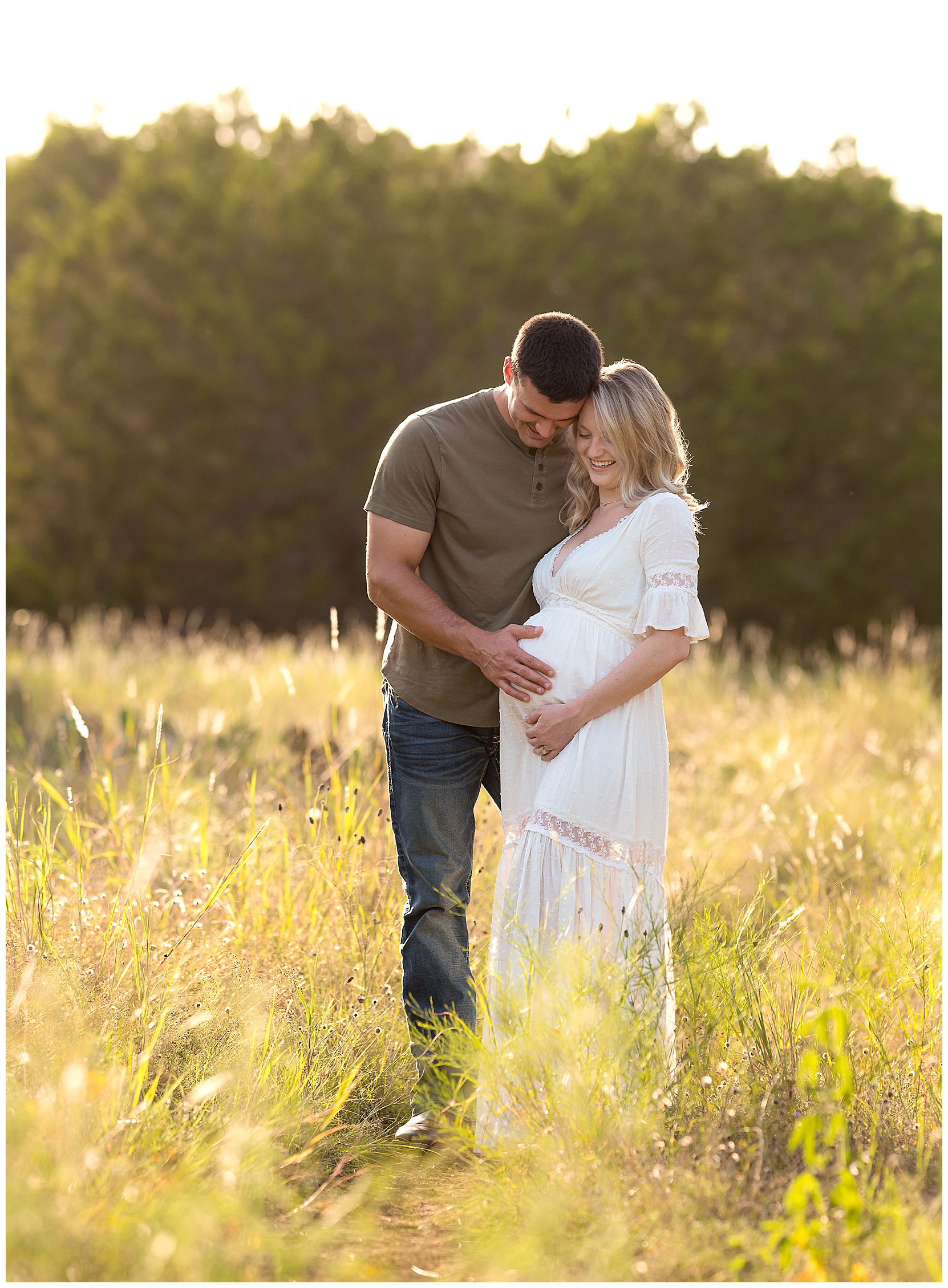 couples maternity photos in a sunny field