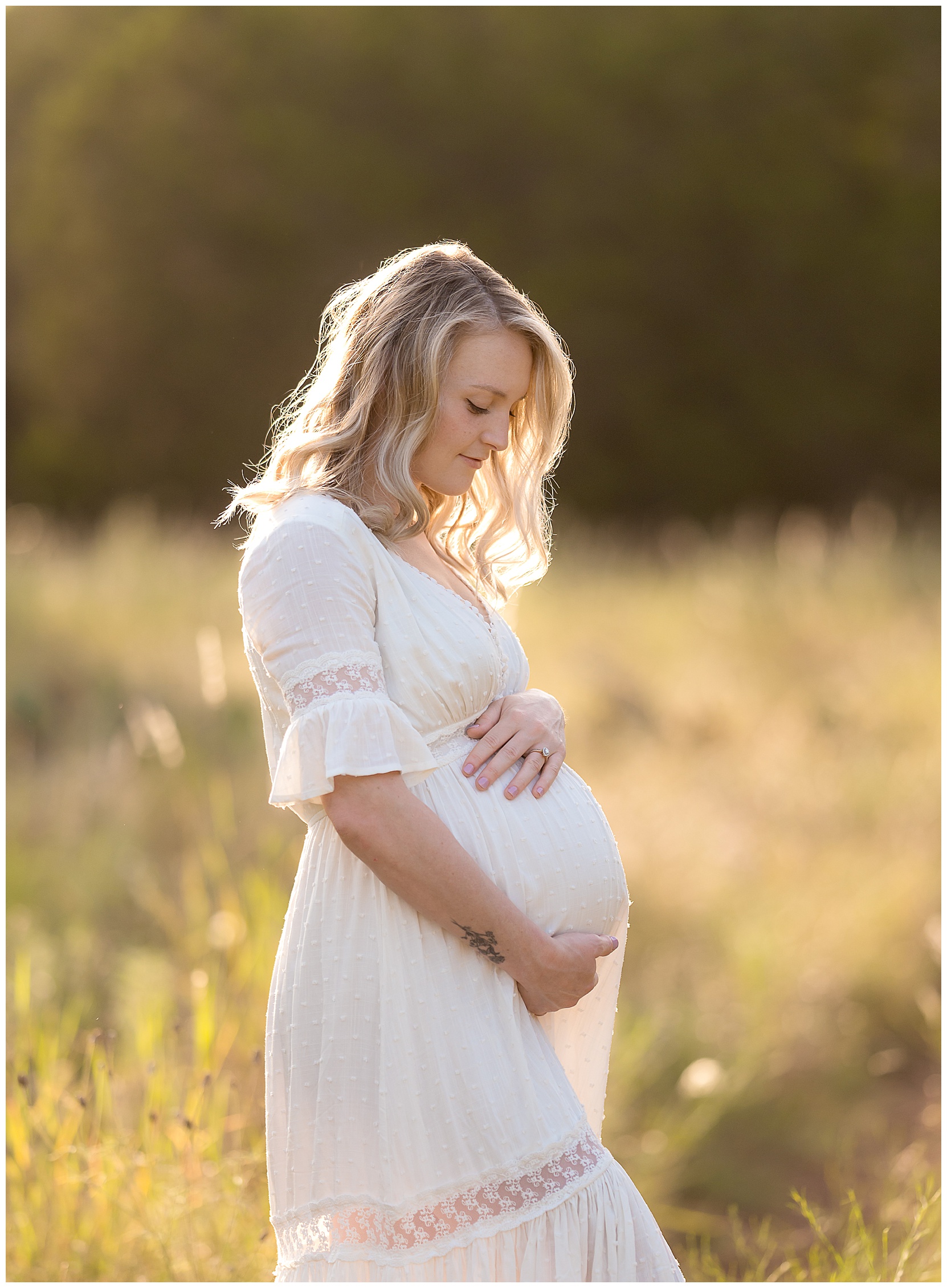 pregnant woman wearing a white dress holding her baby bump