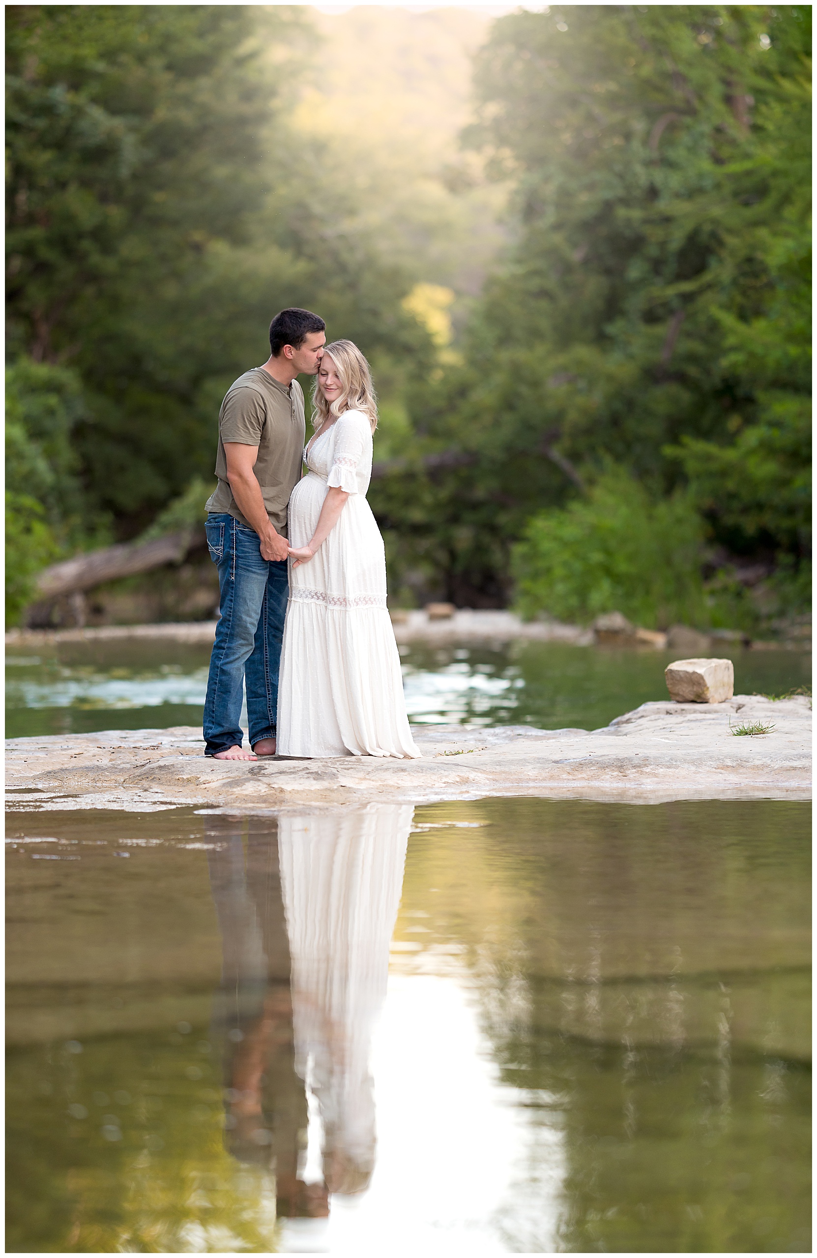 maternity photo of a couple with their reflection in the creek