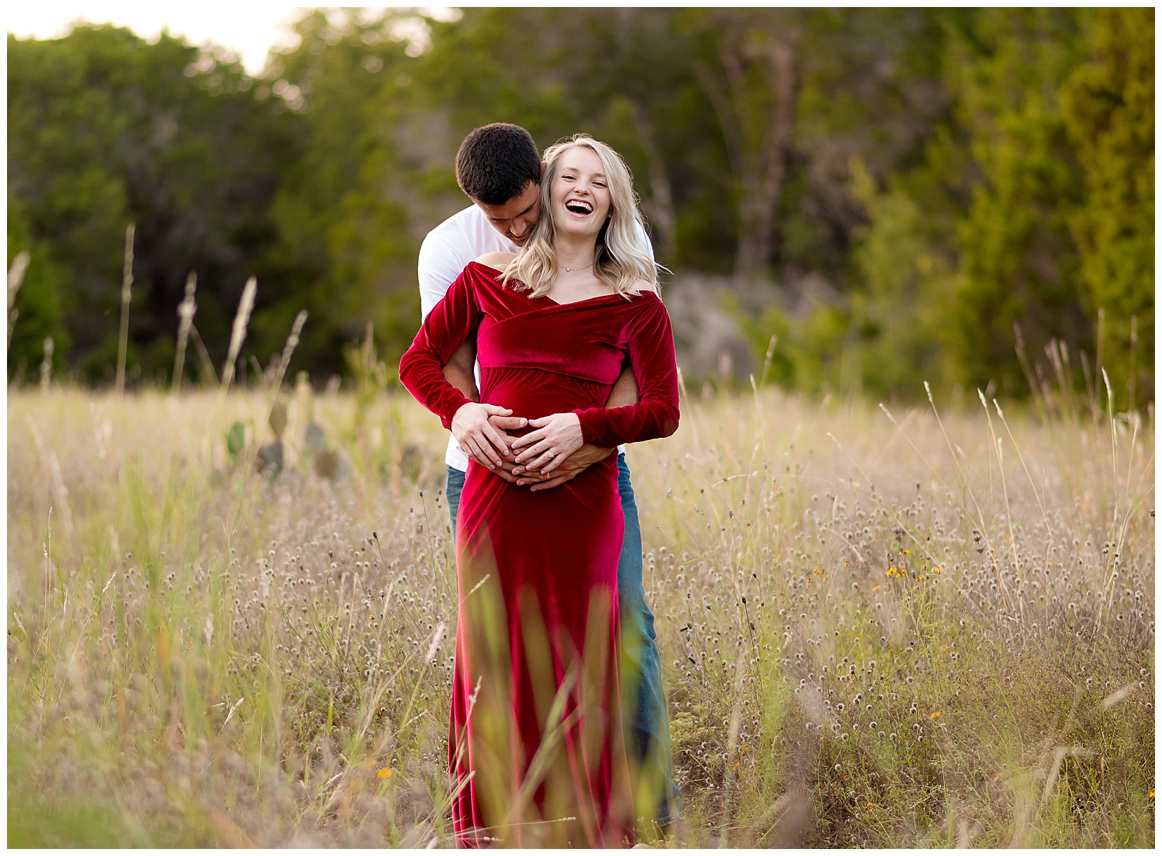 photo man and pregnant woman laughing together in a field