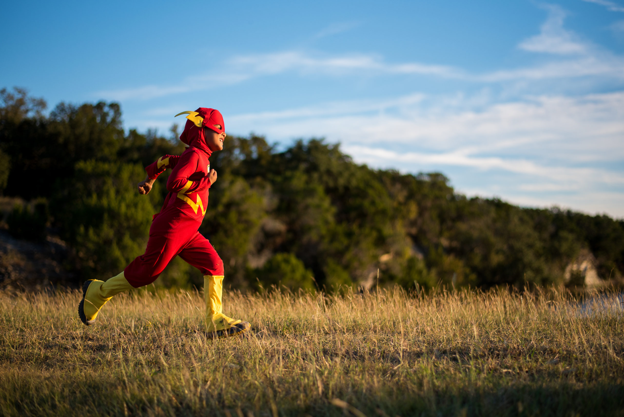 boy running in flash halloween costume