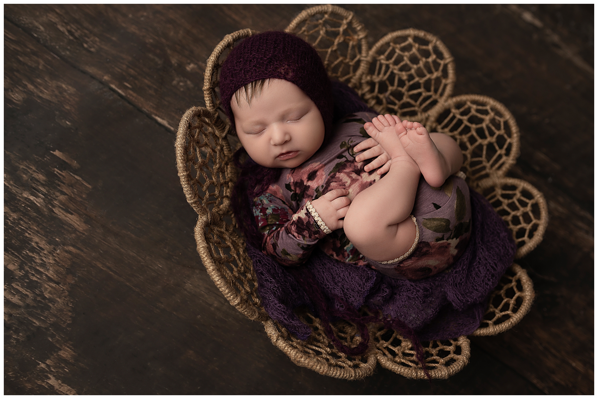 baby in purple sleeping in a webbed bowl