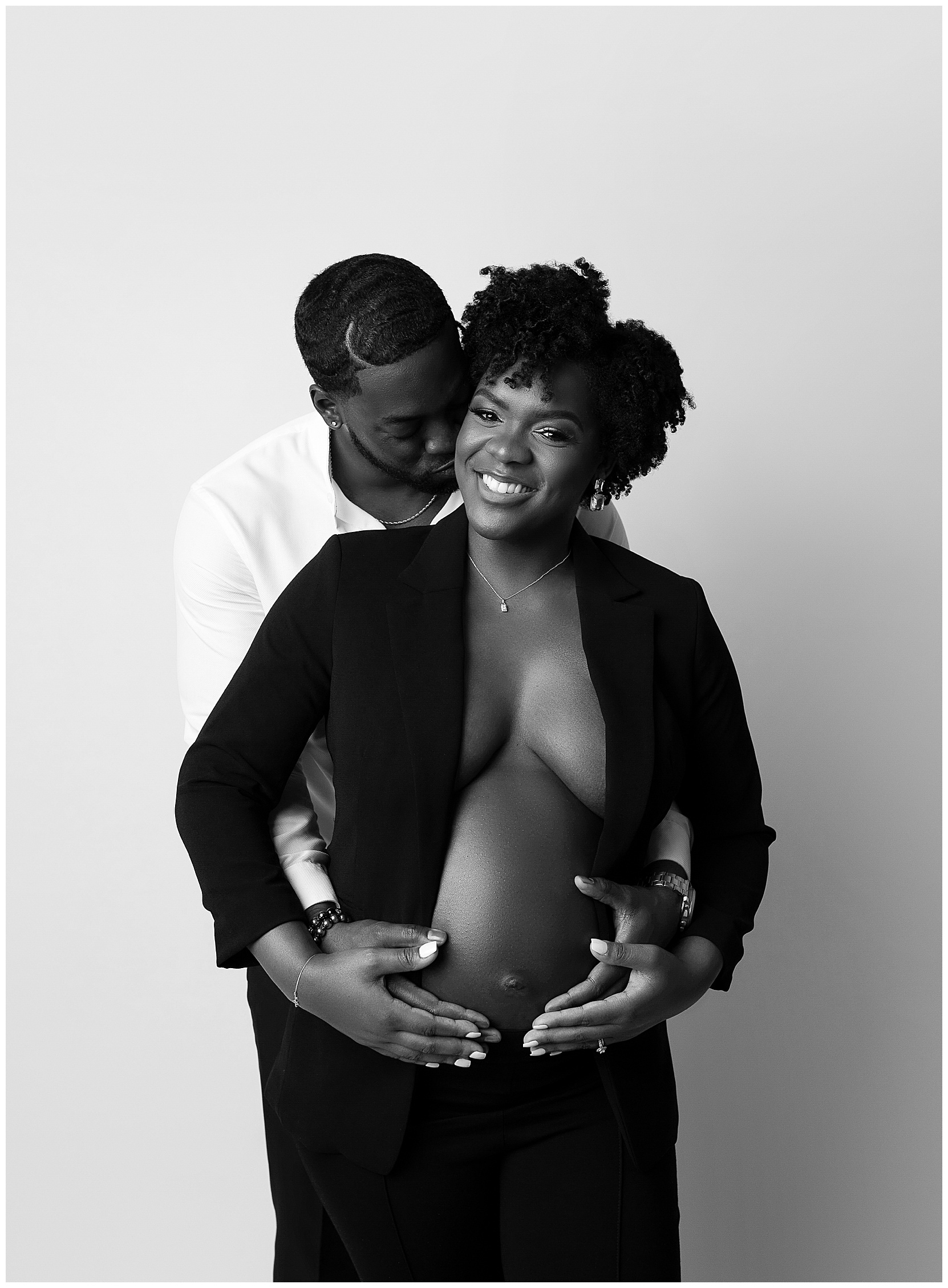 pregnant woman holding belly open black blazer