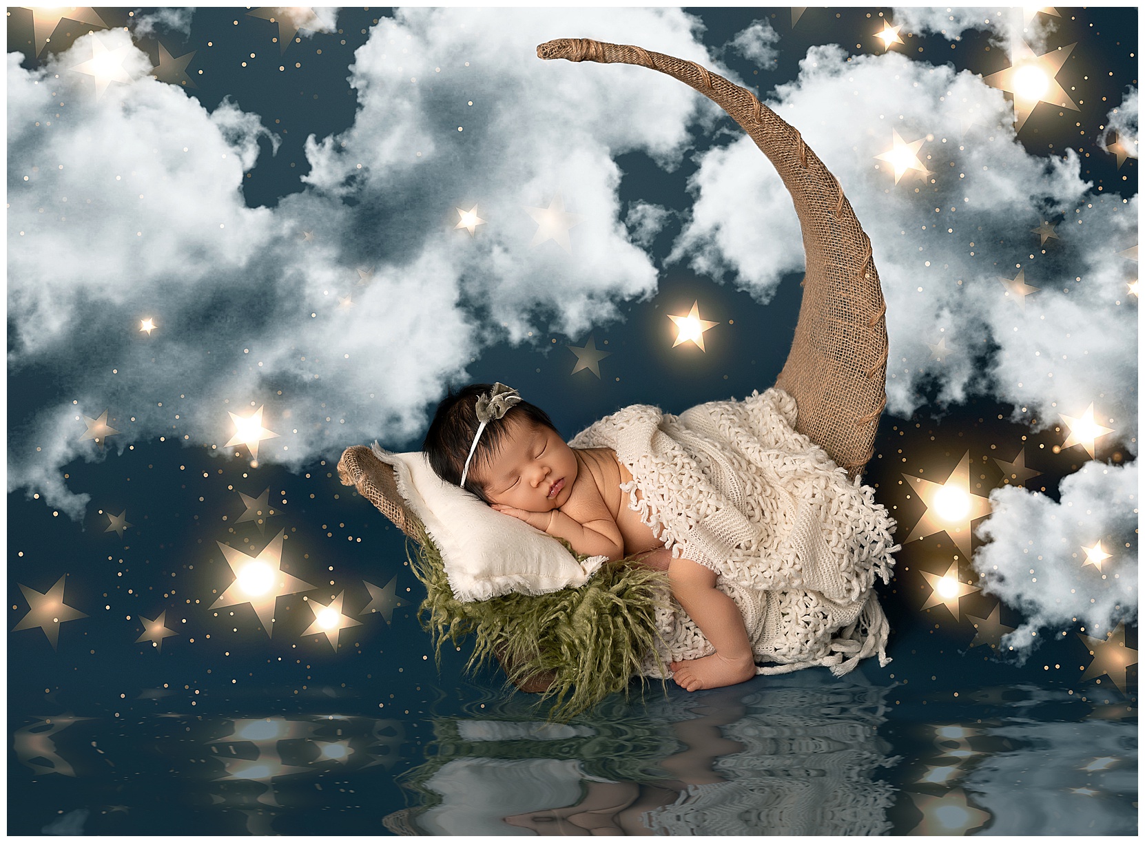 Baby only photography featuring a newborn girl on a natural cloth moon prop set on a scene of stars, clouds, and water. 