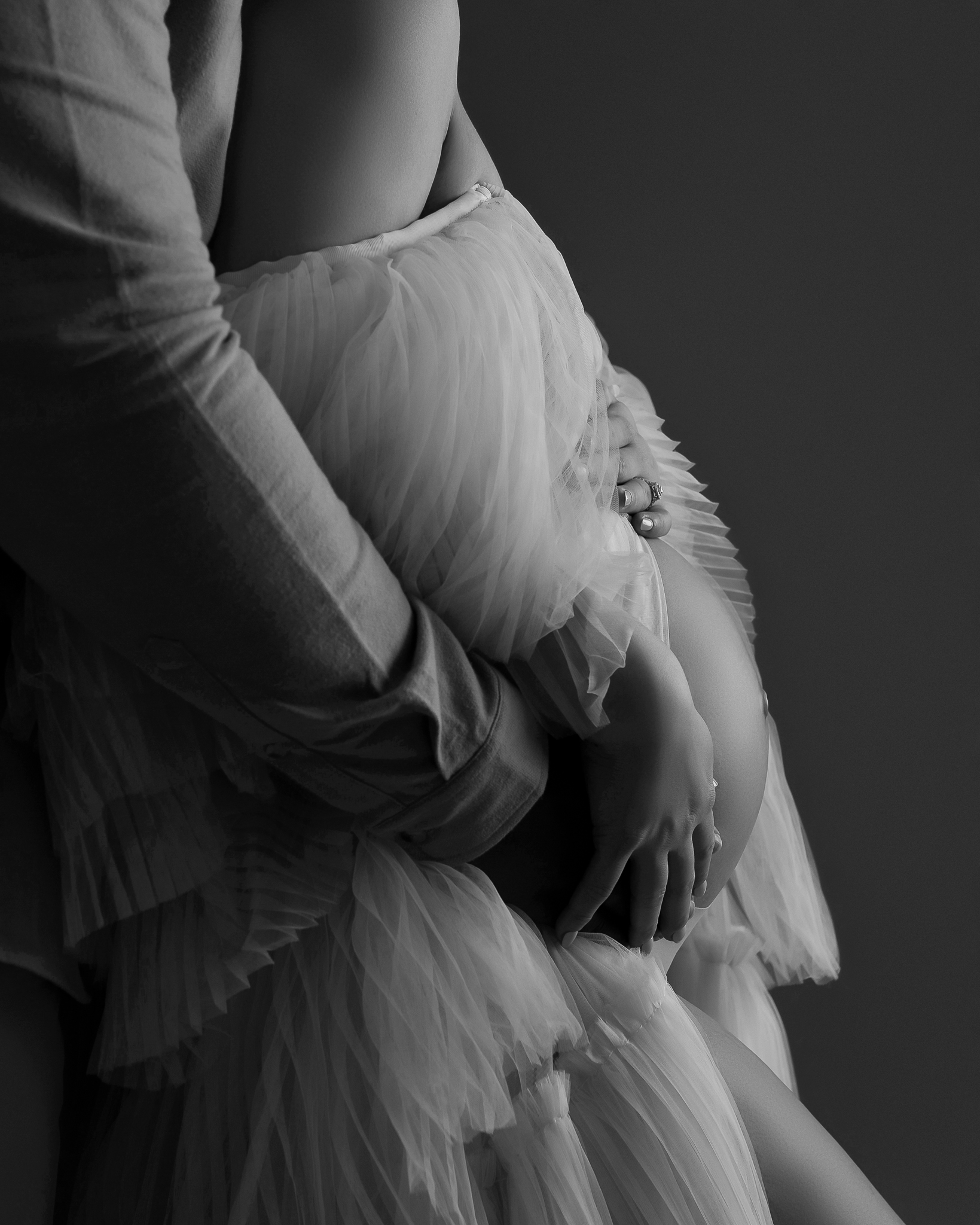 Close up, black-and-white portrait of a baby bump. 