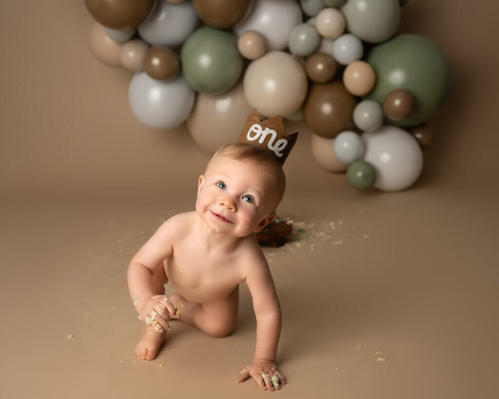 baby wearing one crown during first birthday photohoot