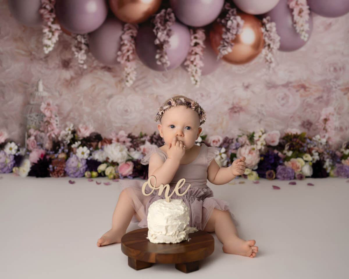cake smash photoshoot purple floral backdrop with balloons