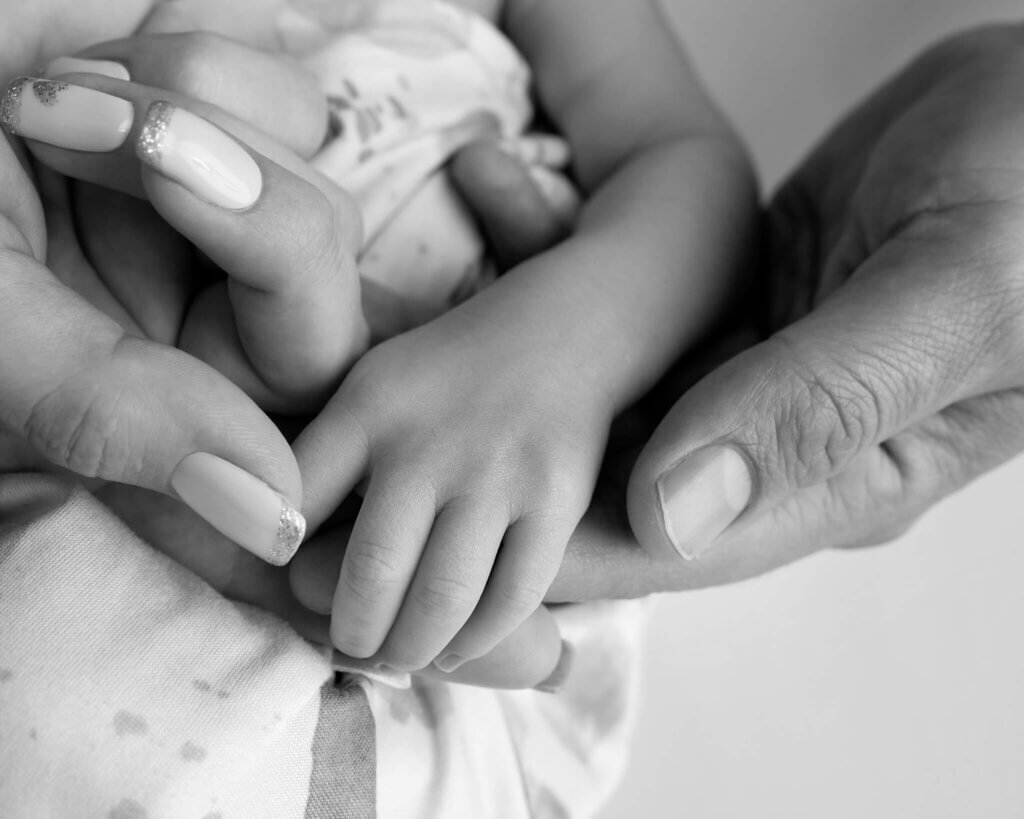 tiny baby hand with mom and dad's hands