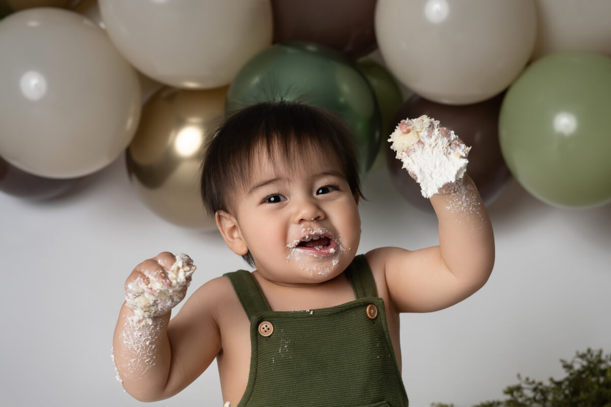 happy boy with fist fulls of cake
