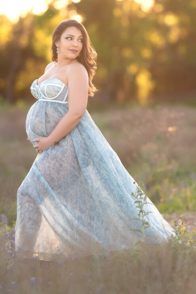 stunning momma wearing blue floral gown during pregnancy photoshoot in austin