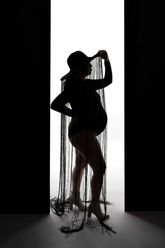 powerful pregnancy pose black and white woman black hat with tassles