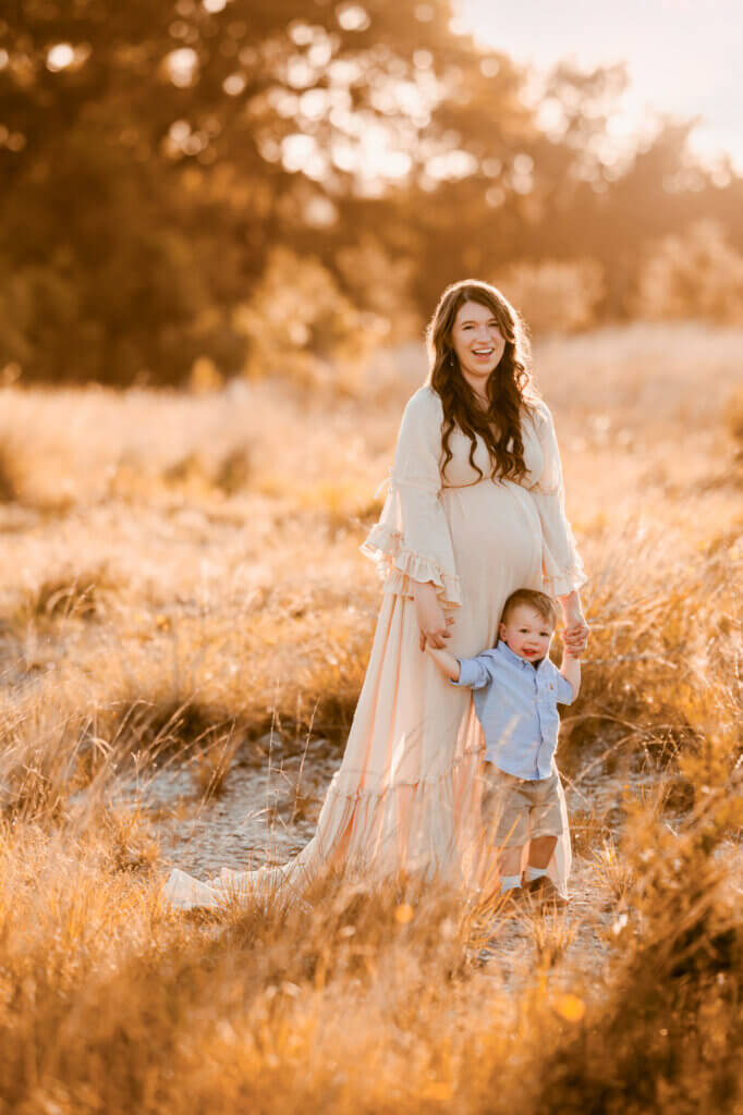 pregnant mom wearing ivory boho dress with toddler son