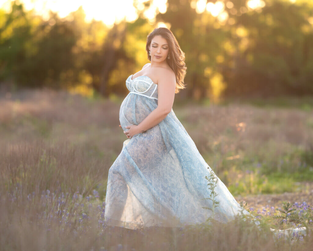 backlit maternity photos in the Texas sun surrounded by wildflowers
