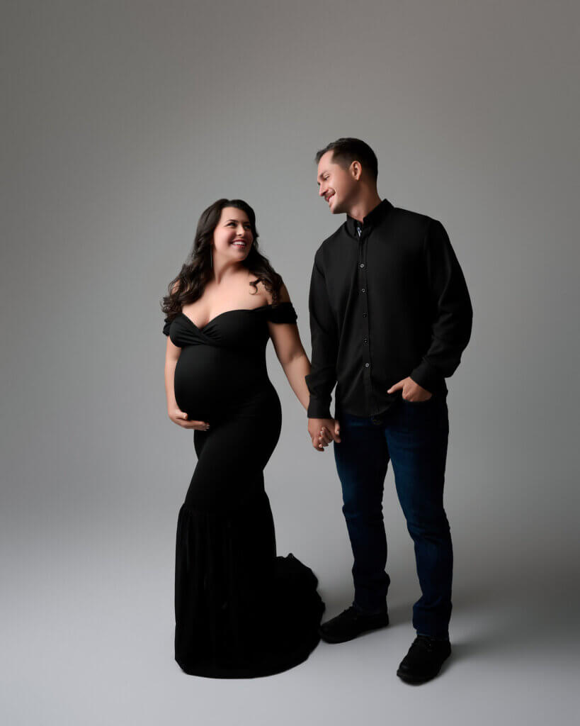 pregnancy photoshoot couple wearing black and walking together