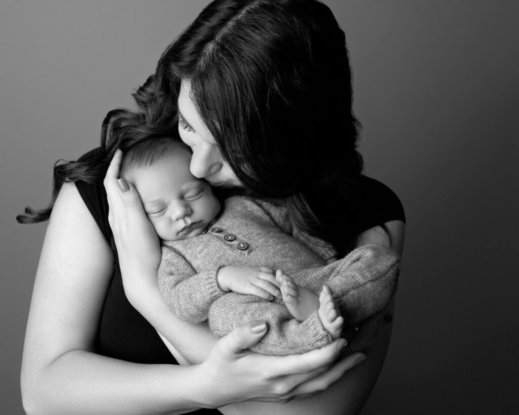 mom holding baby boy kissing forehead