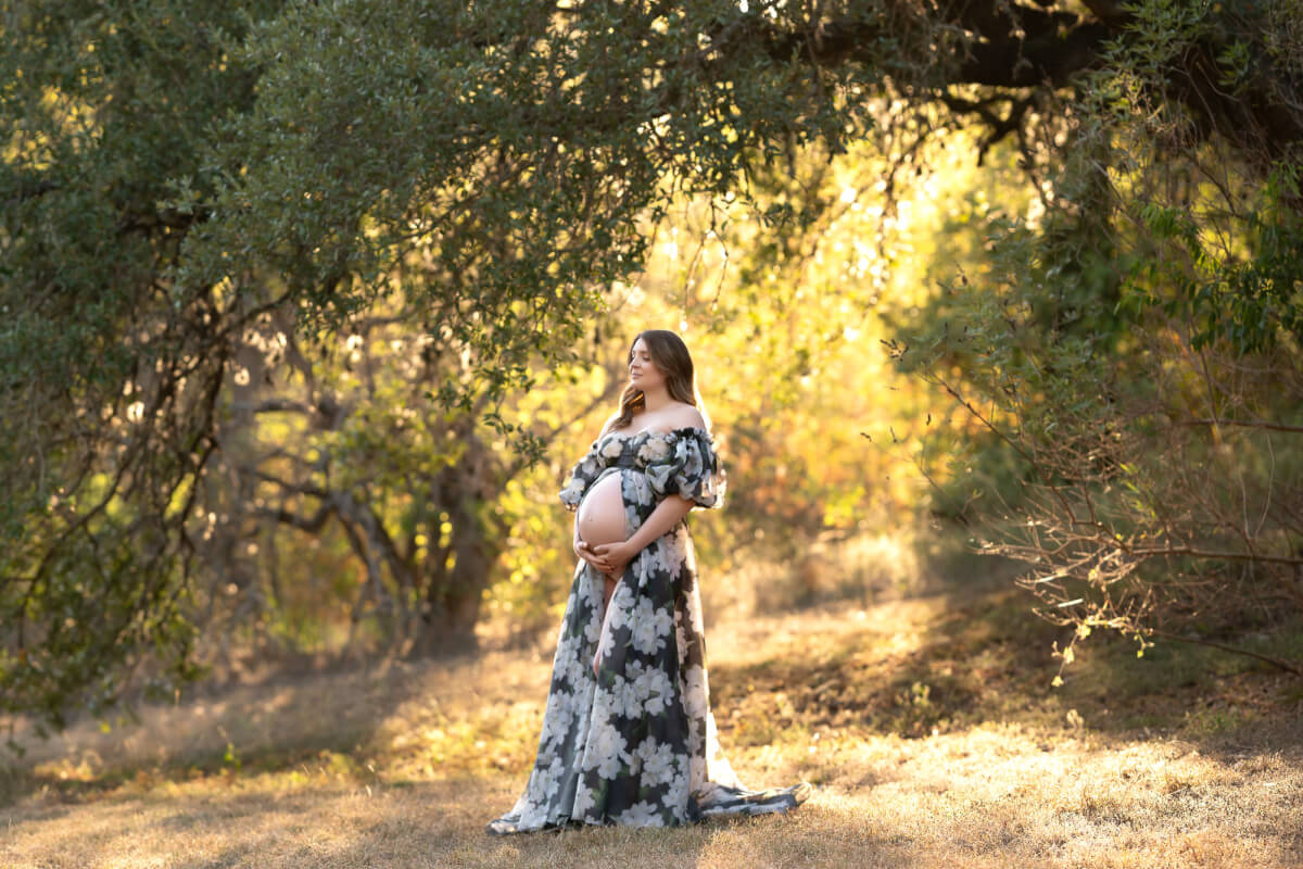 woman wearing black floral gown in wooded area