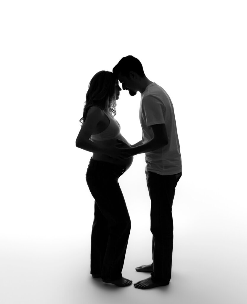 black and white silhouette photo of pregnant couple having a moment
