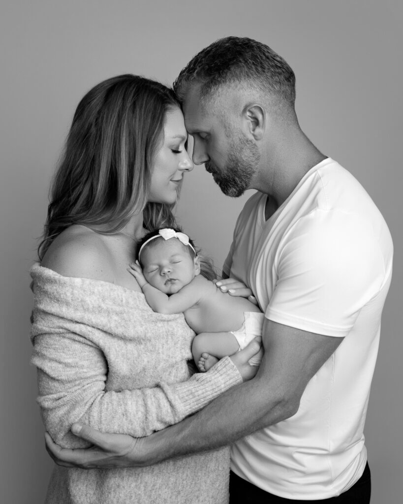 black and white parents holding newborn baby 