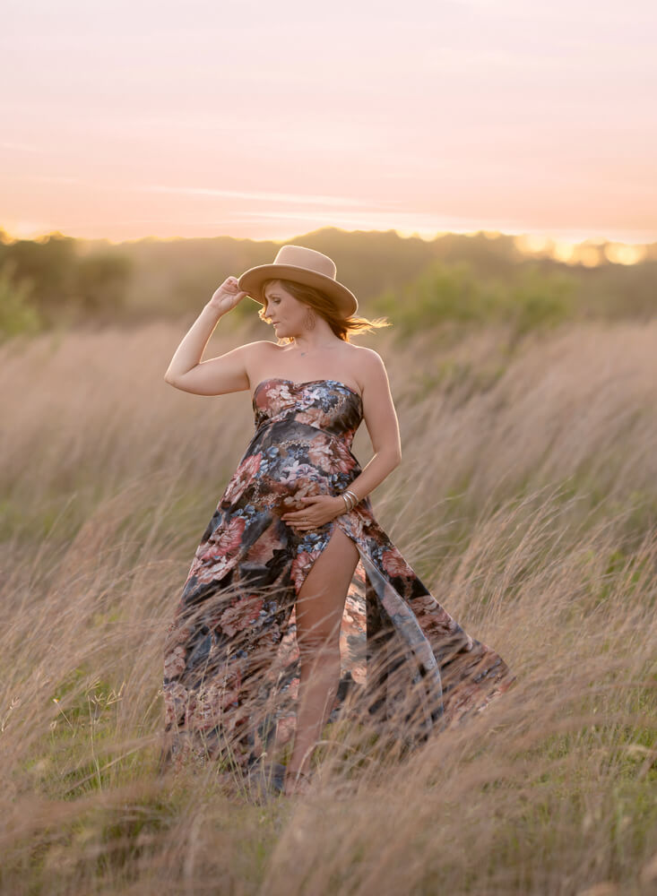 golden hour maternity photographer Balcones Canyonlands Texas woman in floral gown tall grasses