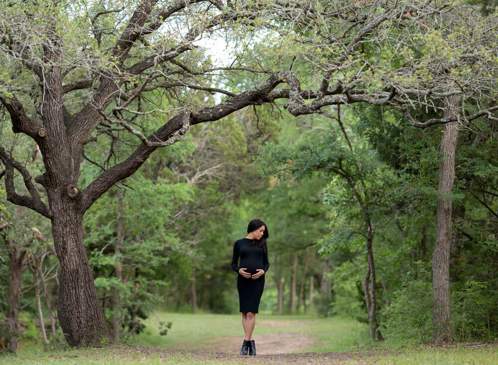 Cedar Park maternity photographer woman in white dress wooded trail Brushy Creek Sports Park