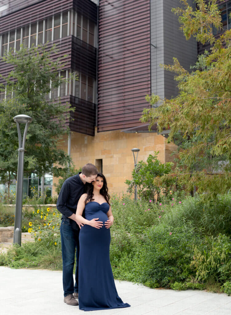 couple maternity photos Seaholm district downtown Austin Texas ivy wall navy gown