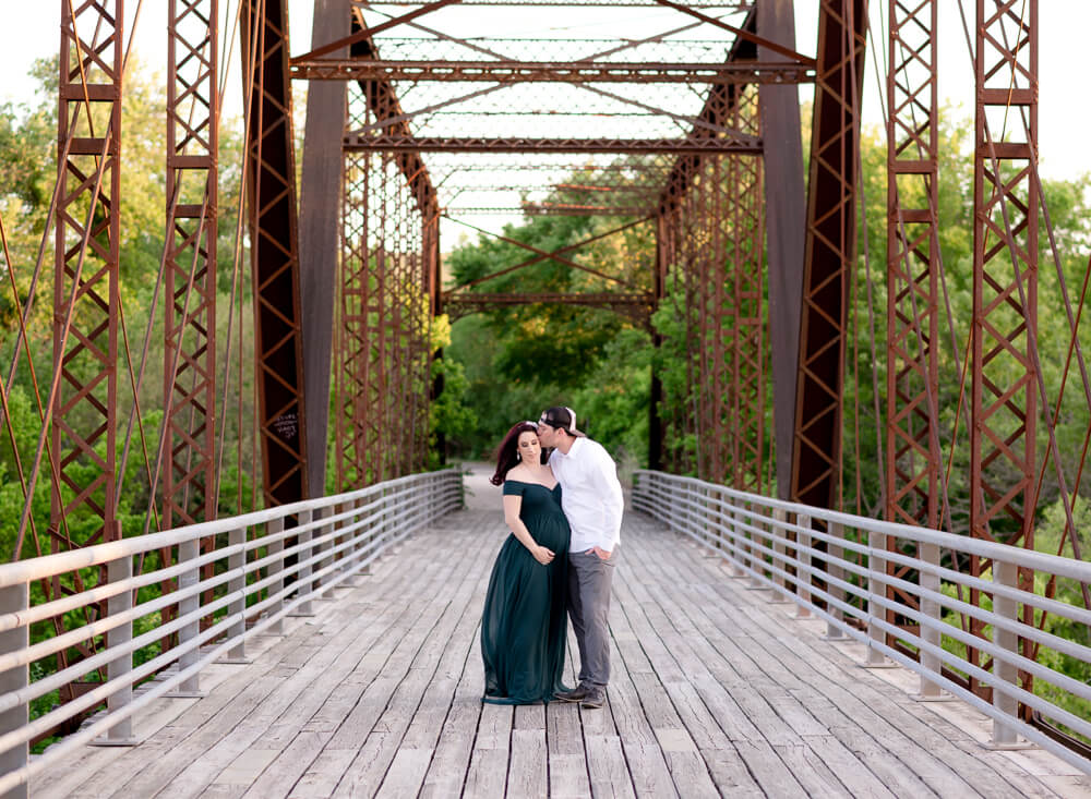 couple maternity photos on historic bridge Richard Moya Park Austin Texas teal gown