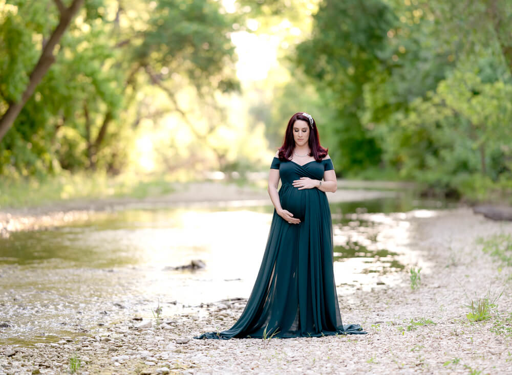 maternity photos by creek at Richard Moya Park Austin Texas teal gown rocky area