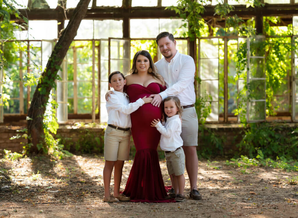 family maternity session outdoor grounds Sekrit Theater East Austin Texas pergola red gown