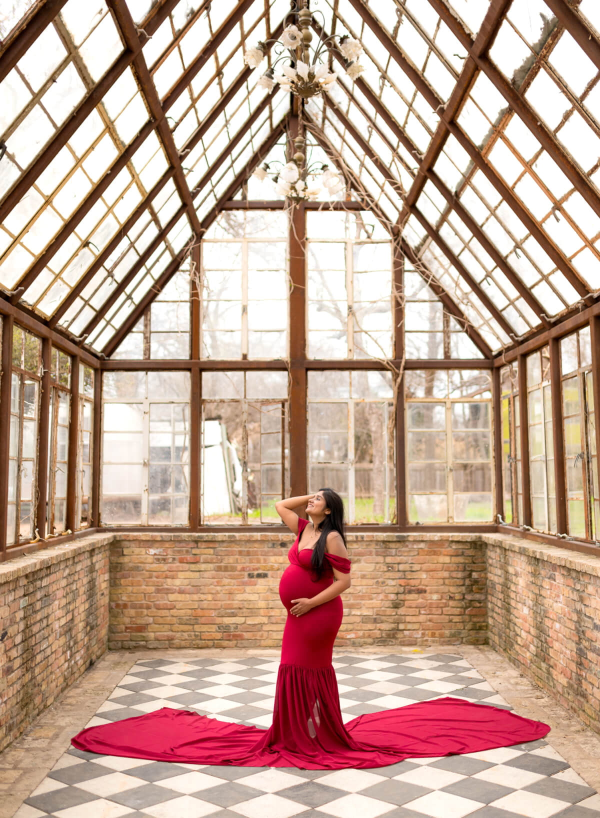 maternity photos inside greenhouse Sekrit Theater Austin Texas checkerboard floor red gown