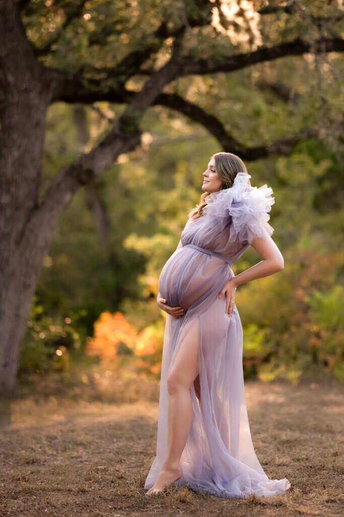 Pregnant mom in a flowing gown at golden hour during an outdoor maternity session