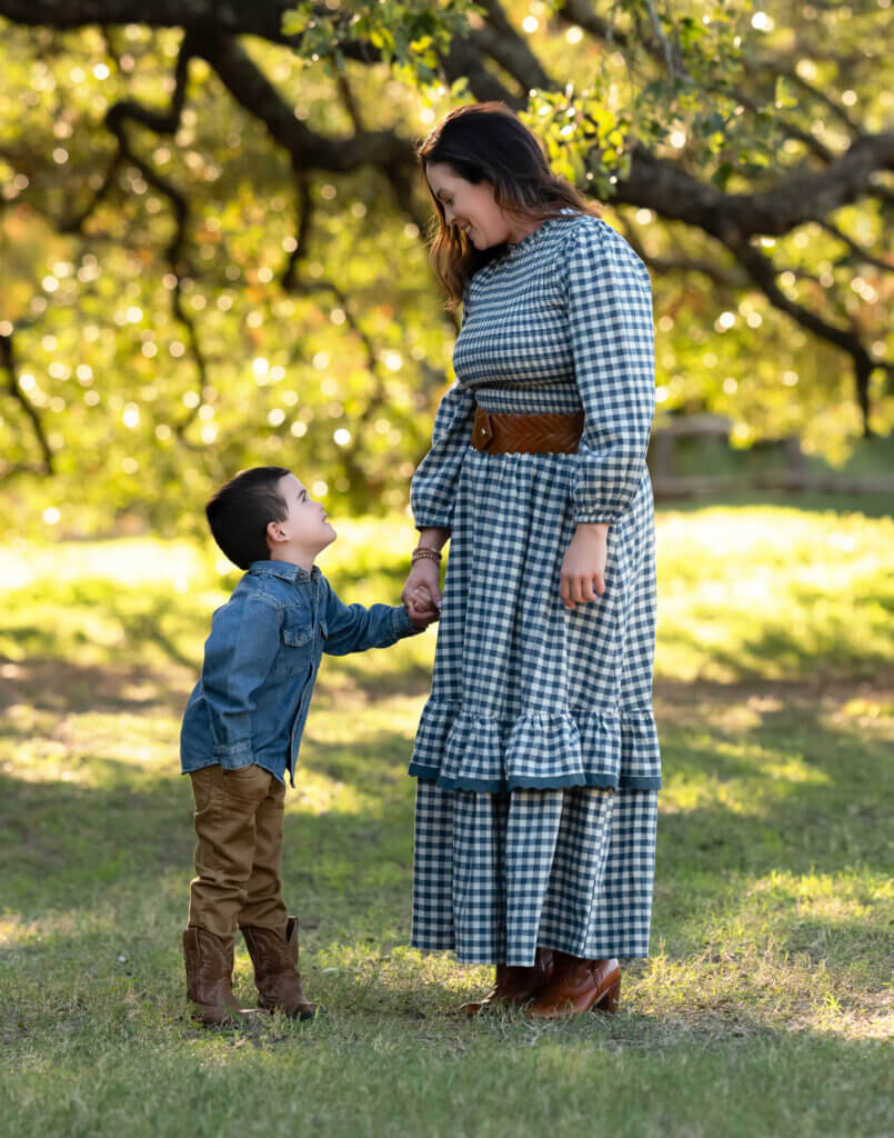 Mother in a blue gingham dress with her son in neutrals for a coordinated family photo outfit