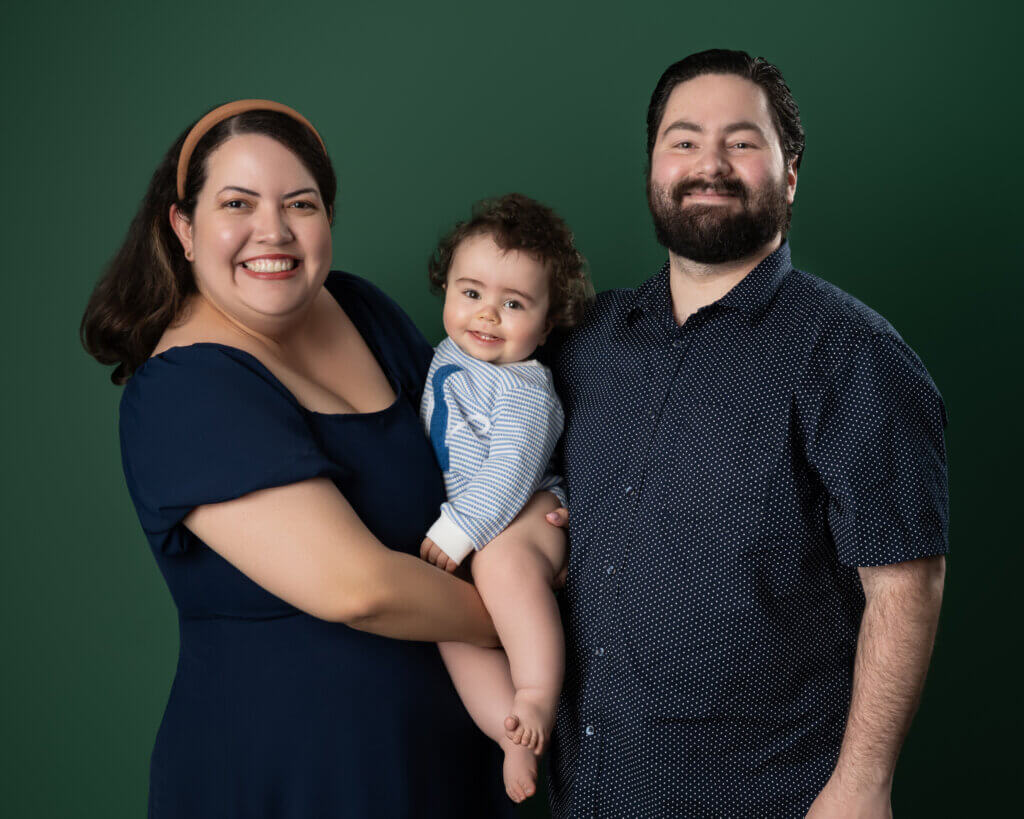 Family in navy and light blue on a green studio backdrop showing a coordinated color palette
